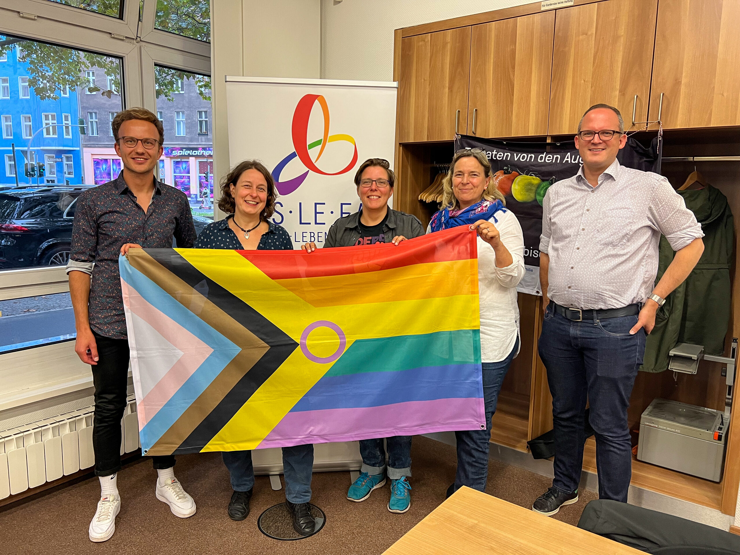 Mathias Schulz und Weitere mit einer Prideflagge